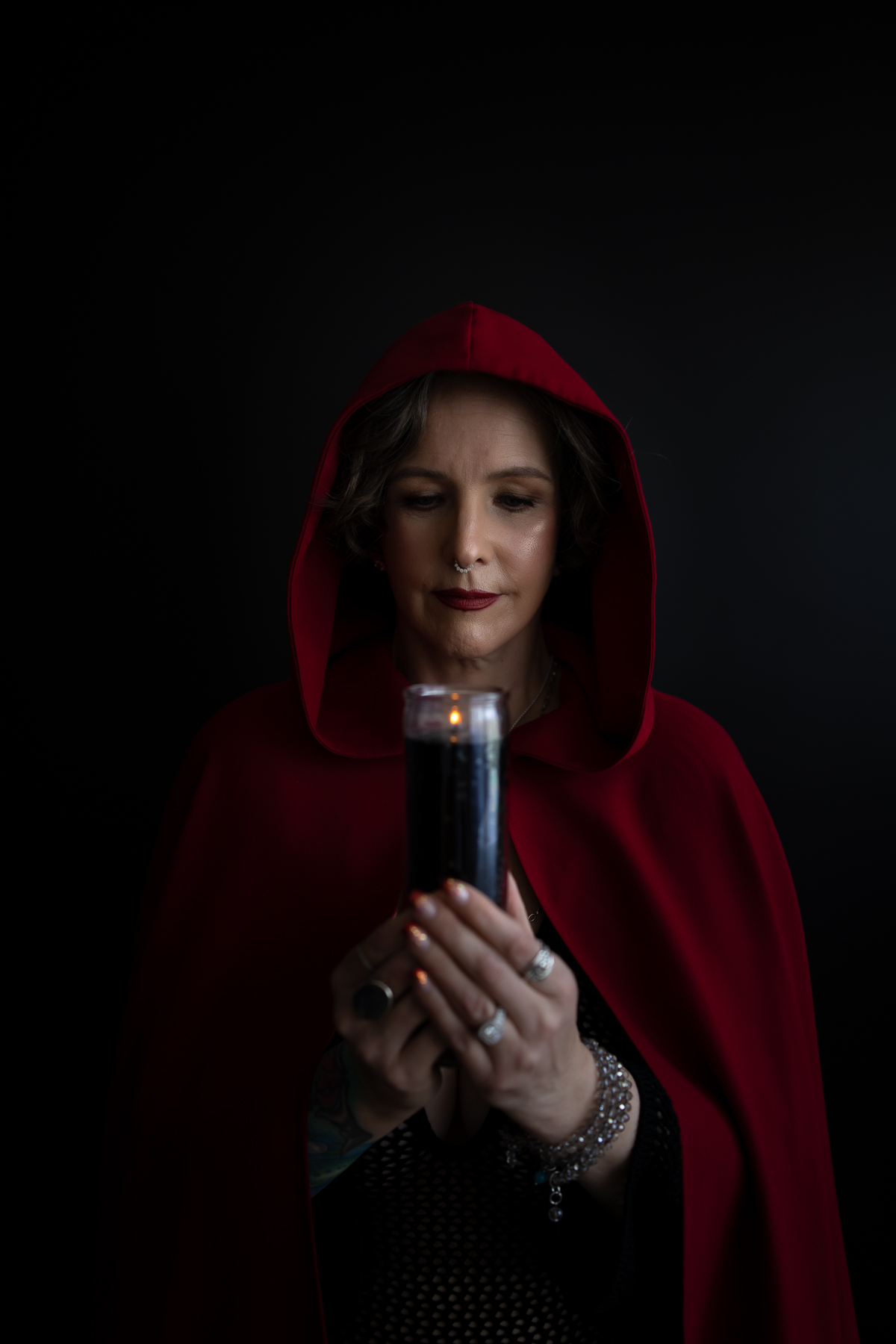 witchy-boudoir-photoshoot-sonoma-county witchy woman holding candle with red cloak
